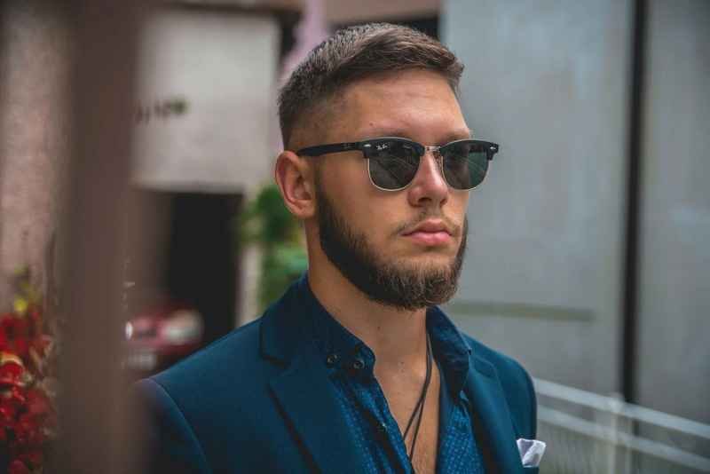 Men's Haircut Trends 2023 - Side profile of a man sporting a neat and tidy crew cut in a minimalist barbershop 