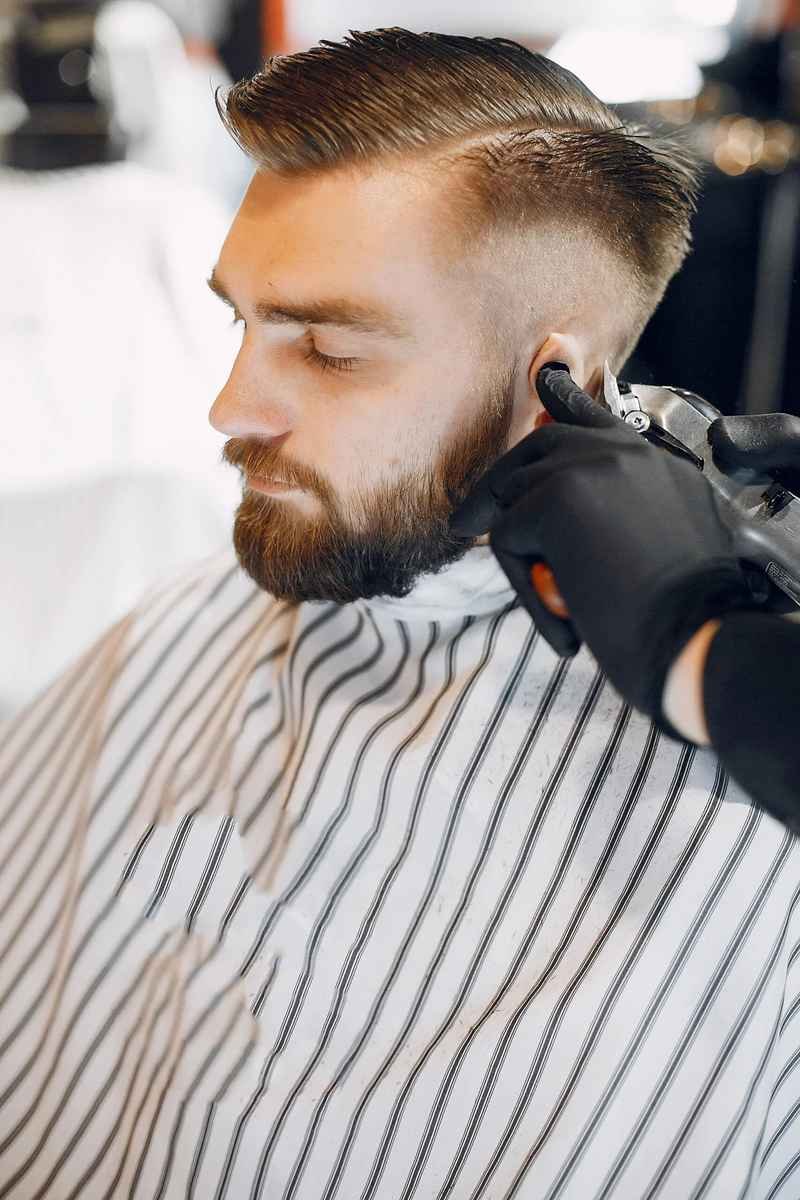 A man with a precision fade haircut in a modern barbershop setting