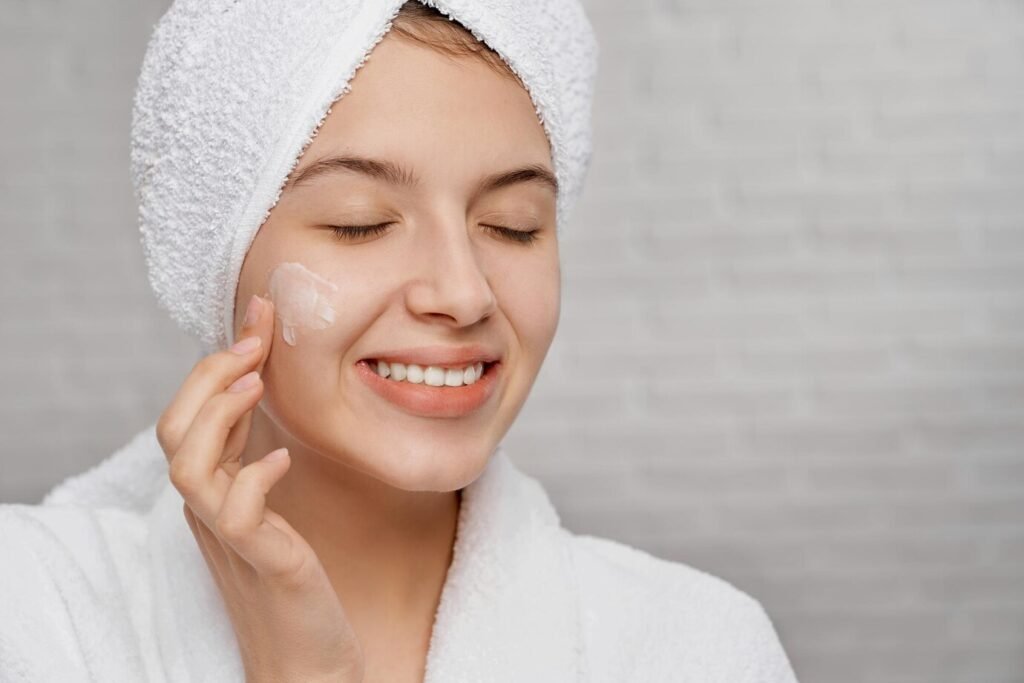 Woman practicing winter skincare routine in a snowy landscape.